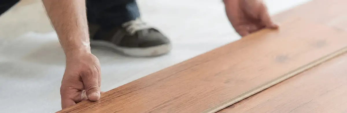 A professional installing laminate flooring in San Antonio, TX